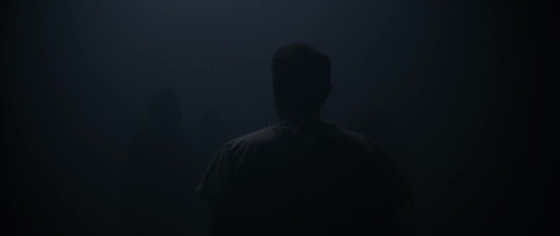 The man walks into the very dark thick fog