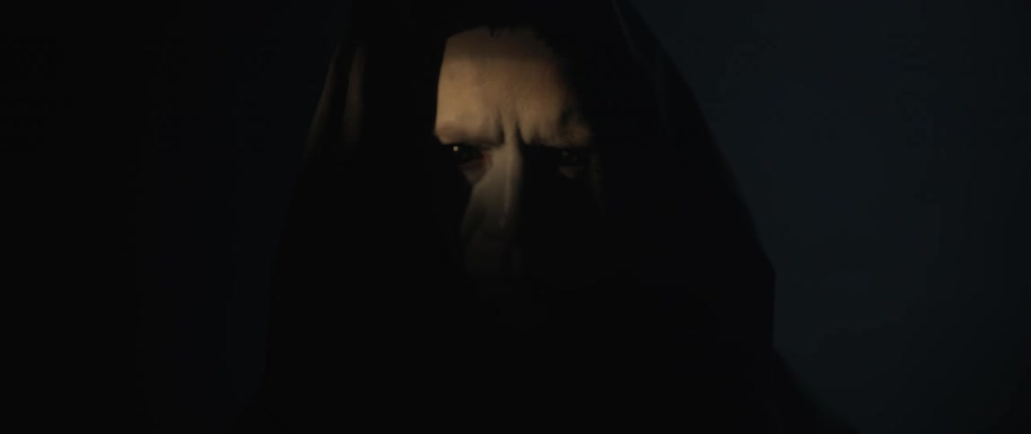 A man in dark robes creeps up in the dark