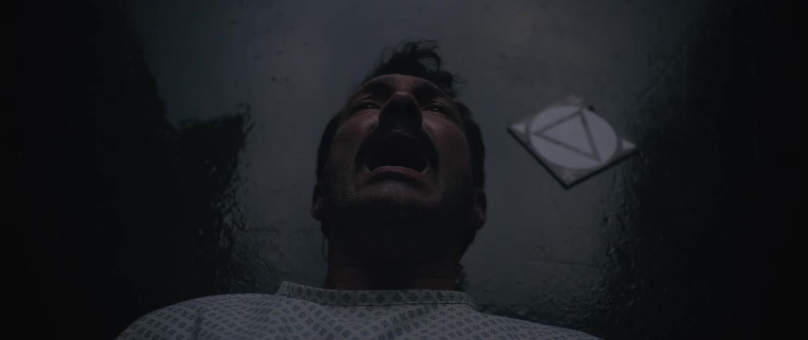 A man screams as he is beaten on the floor