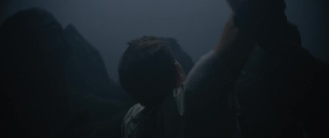 Man fighting with hooded people in a dark environment