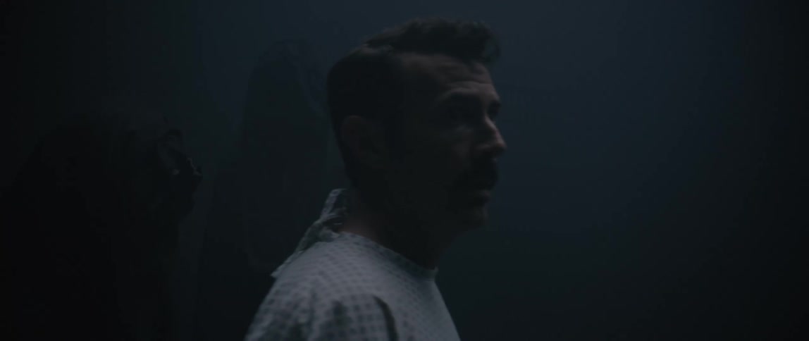Man with scared expression being caught off guard in a dark room