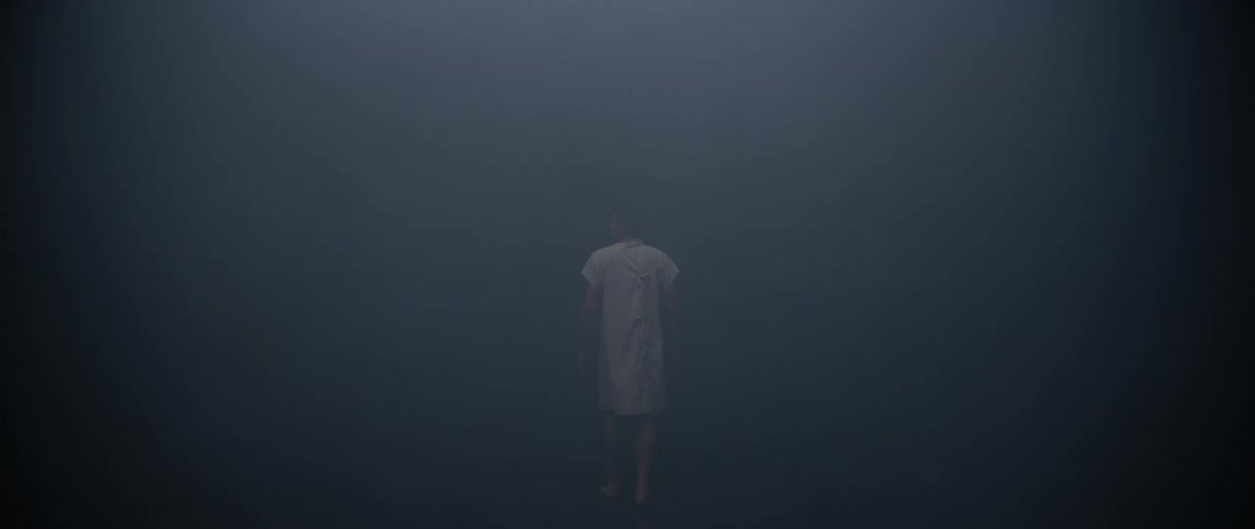 Person in a white apron walking in a dark room
