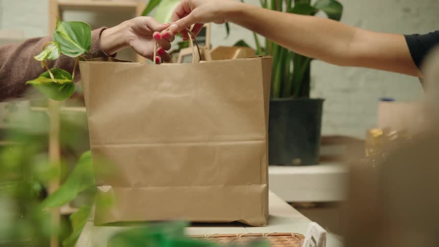 The employee hands a bag to the customer