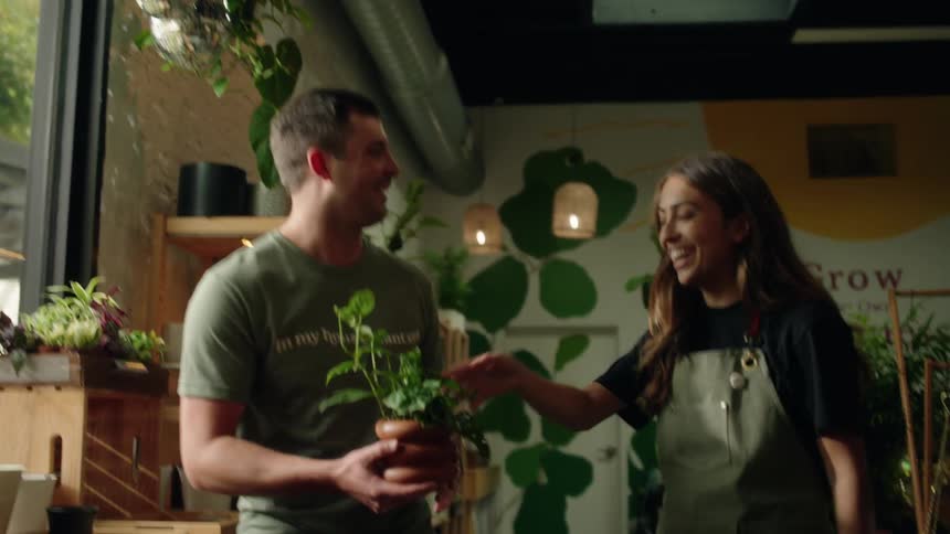 A man buys a plant and leaves the store