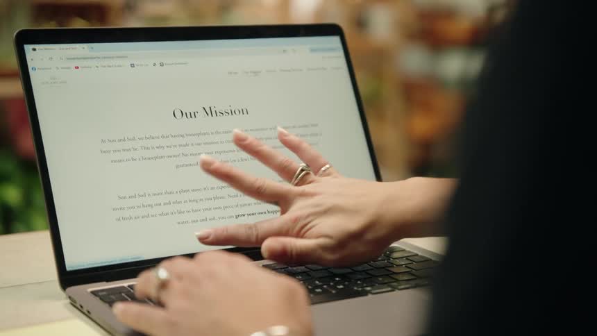 A woman is scrolling through photos on the laptop