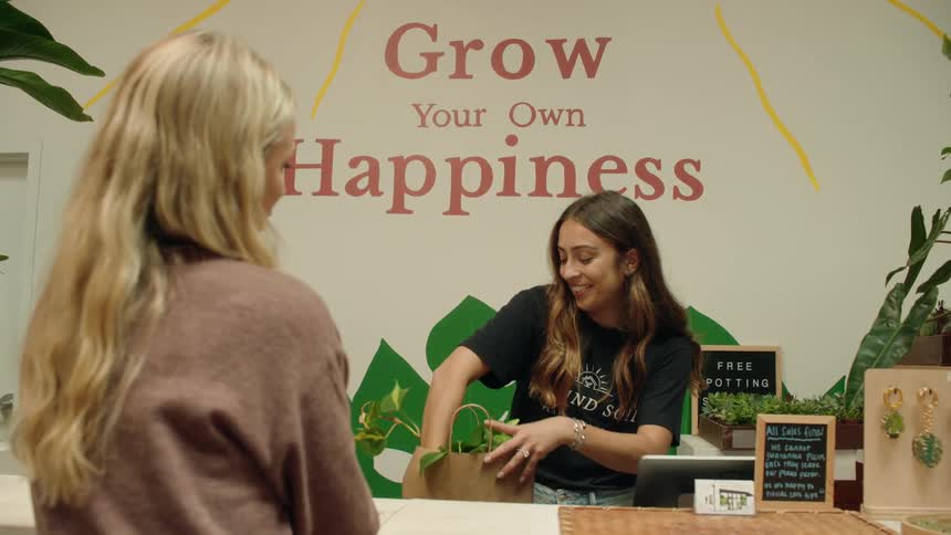 The employee bags the customers purchase and talks with her