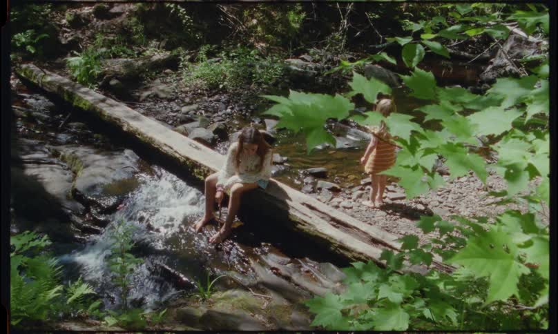 Girls play by the water of the stream