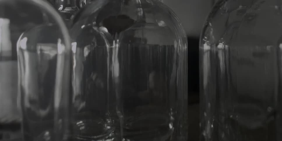 Person setting empty jugs on a shelf