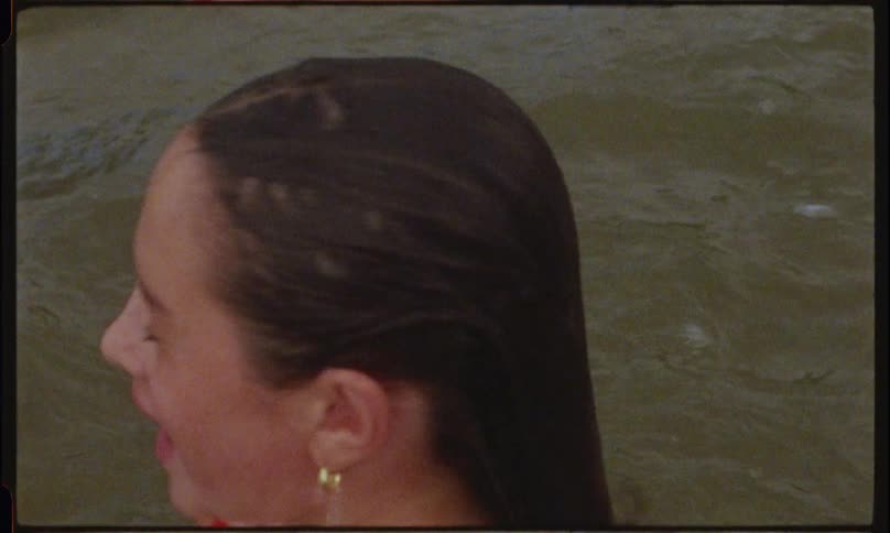 The face of a little girl who is on her back on the surface of a body of water diving