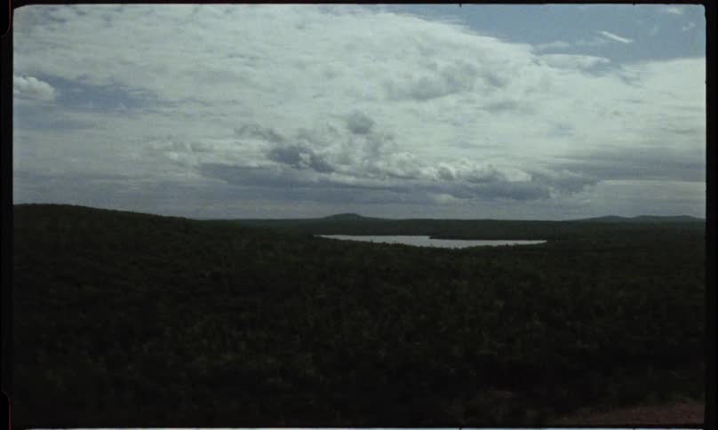 A wide vast vista landscape shot of flat plains in shadow and white heavy clouds in a blue sky