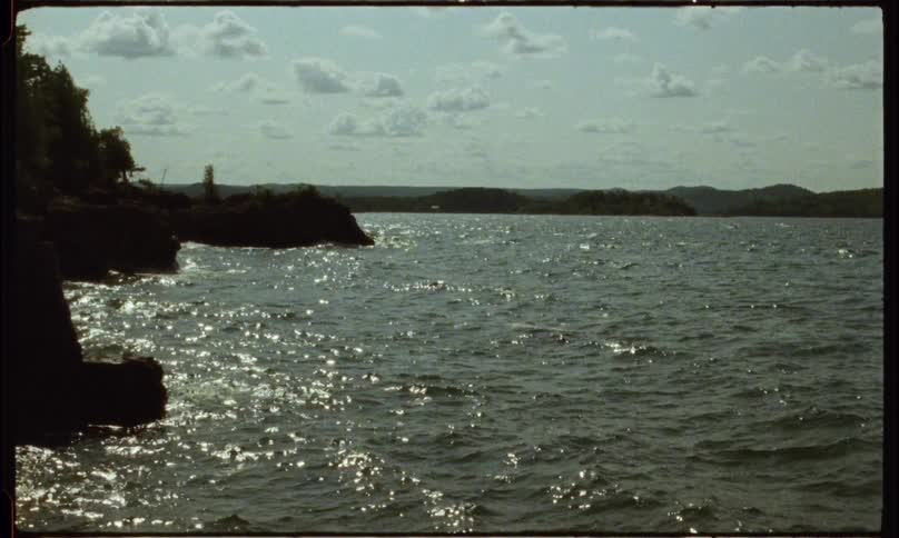 Tiny waves on choppy water roll up to the coastline
