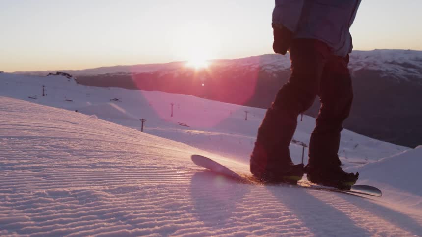 Person snowboarding down a hill at a ski resort