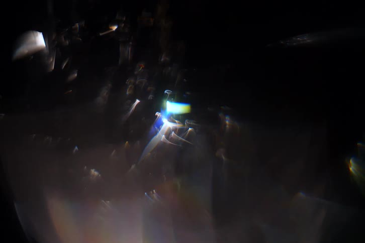 Crystalline shapes rotating in a hazy area reflect the light and create a prism effect