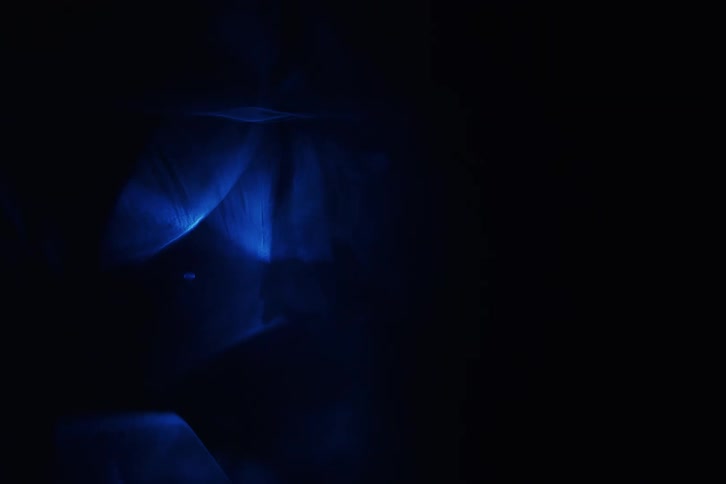 Dark blue light moving in patterns in darkness