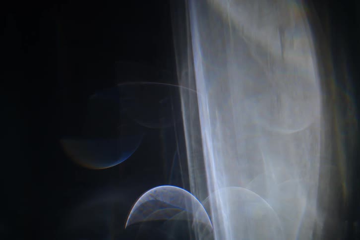 Abstract flares of white lights moving on a black background