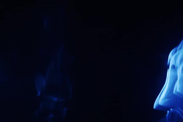 A glowing blue light shape slowly moves across a dark background creating an eerie and abstract visual effect
