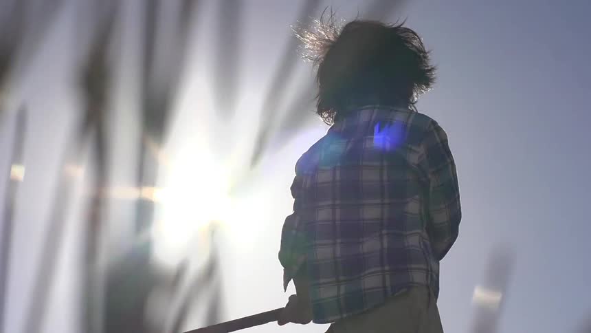 A kid swinging a stick
