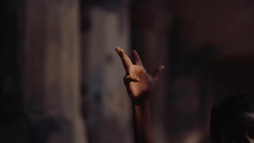 A person reaches their shaking hand up