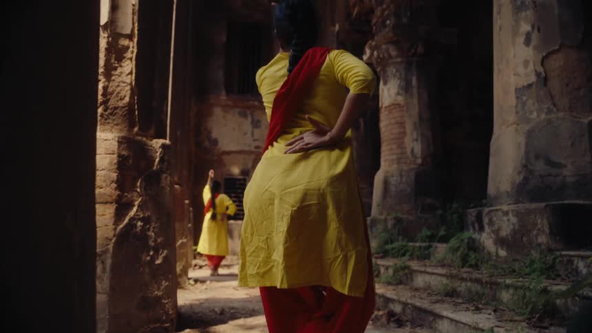 Two women in colorful clothes spin in circles