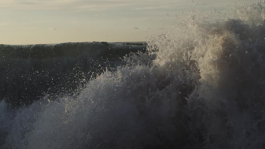 Water splashes and foams as waves roll into shore