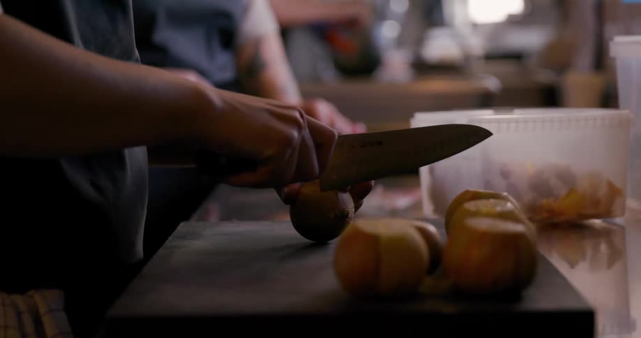 Multiple cooks work in a kitchen during the daytime