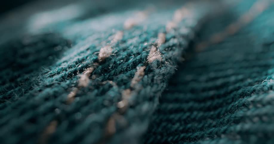 Pale thread forms parallel rows of stitches across a blue fabric