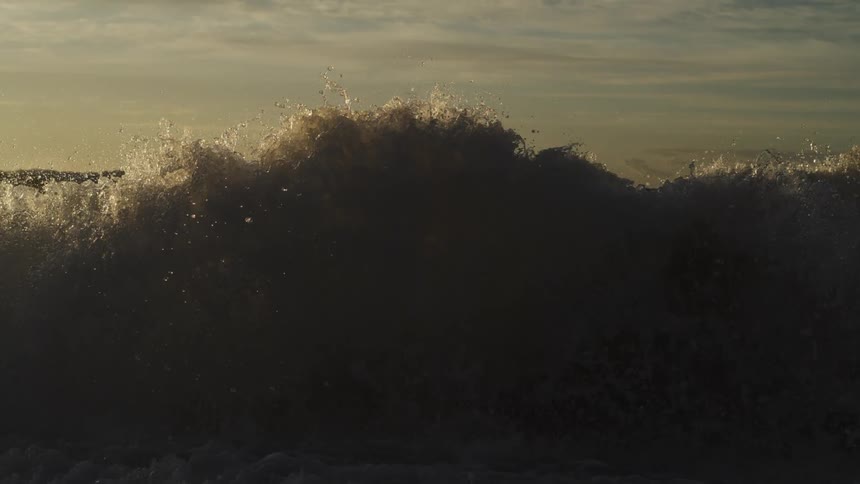 Waves sparkle as they splash and roll into shore along the coast