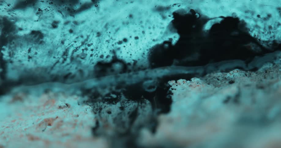 Closeup of a whitish and blue surface with an abstract dense liquid