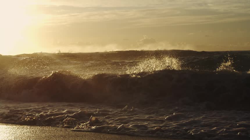 A row of waves are hitting the beach