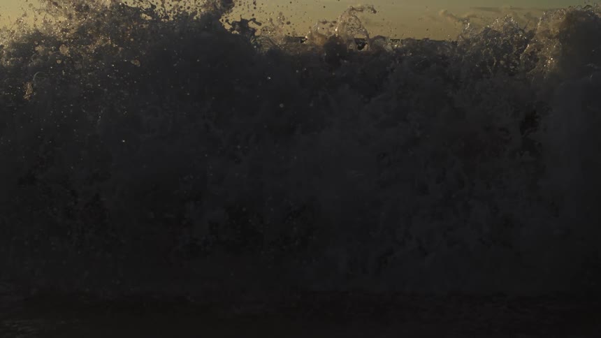 Waves splash as they roll in to shore and over the beach