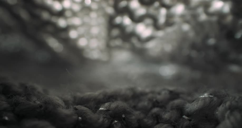 Extreme closeups of a woven textile with moody lighting and shallow depth creating a tunnellike abstract view