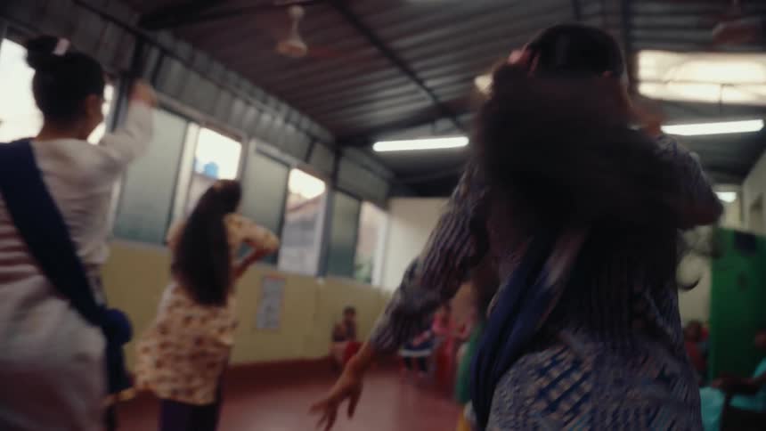 A group of women are dancing as people watch