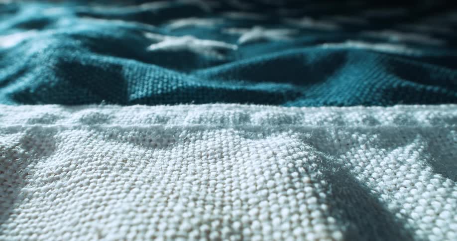A sewing texture blanket with blue white and brown colors and there are white star designs stitched on it
