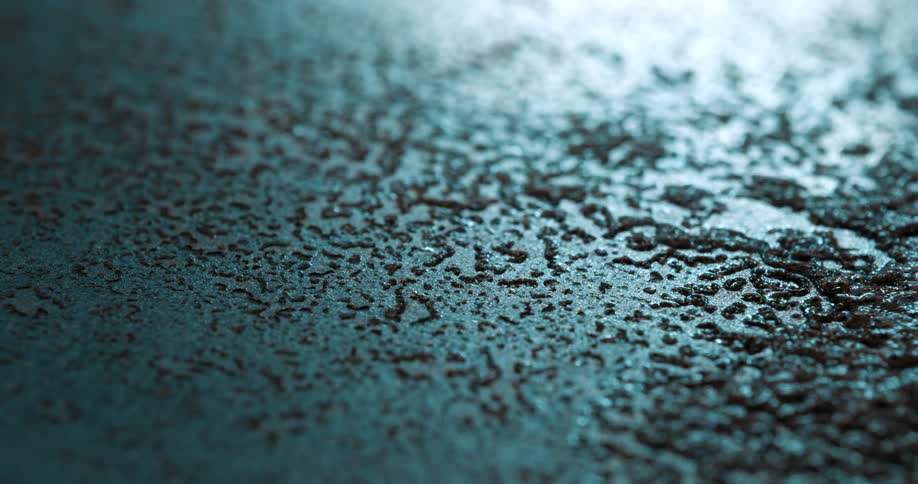 A wet muddy floor with a smooth surface appearing slightly disturbed or uneven from recent activity