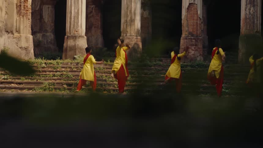 A group of indian women all dressed the same doing a synchronized dance