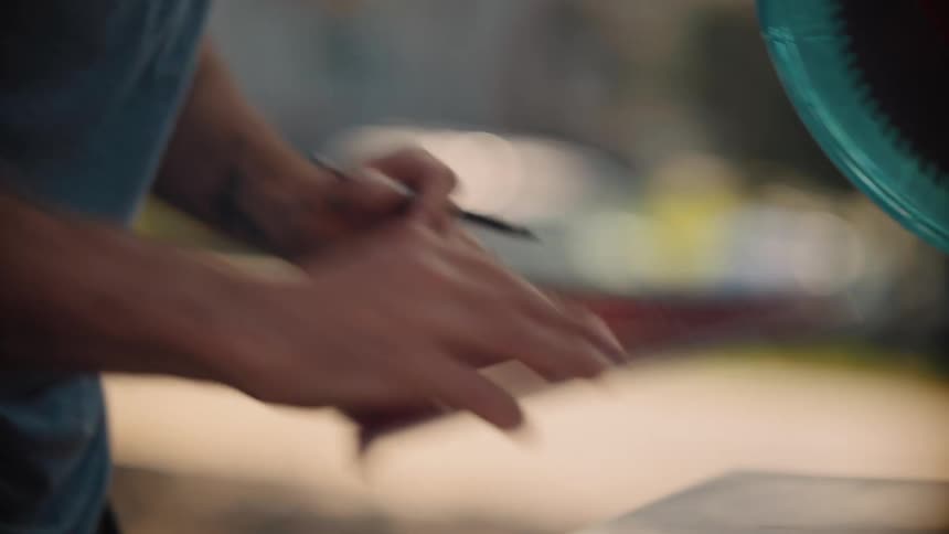 A closeup of a persons hands carefully working with a tool or object on a flat surface possibly measuring or crafting something