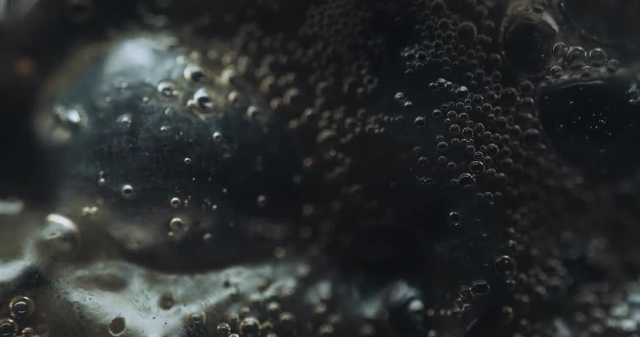 A dense and viscous black liquid with some bubbles that are expanding