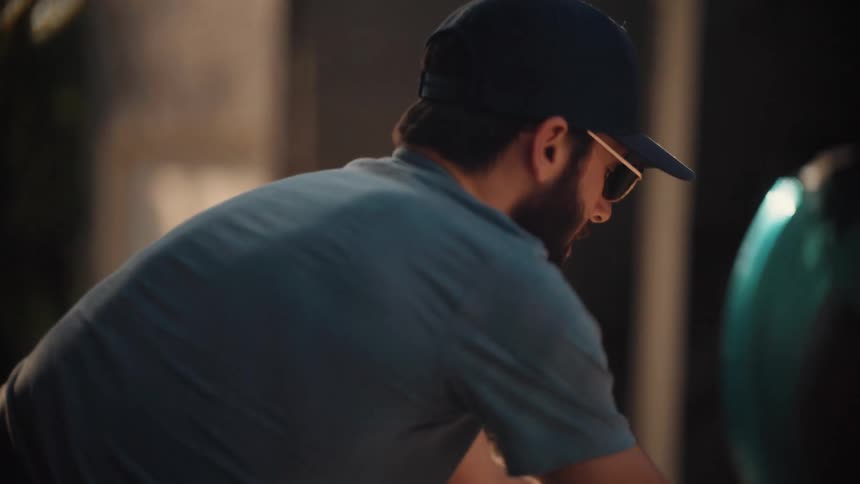 Man taking a piece of wood and placing it over another to compare the size