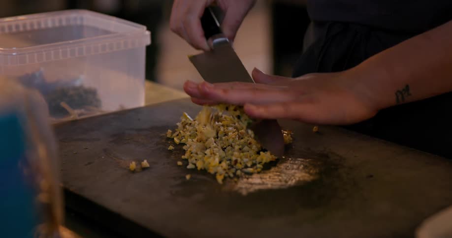 Cook dices an ingredient while working in a restaurant kitchen