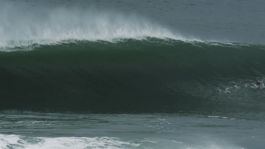 Wave splashes and curls as it rolls in to shore