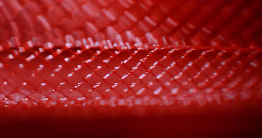 Red mesh flows by against a black and red gaseous background