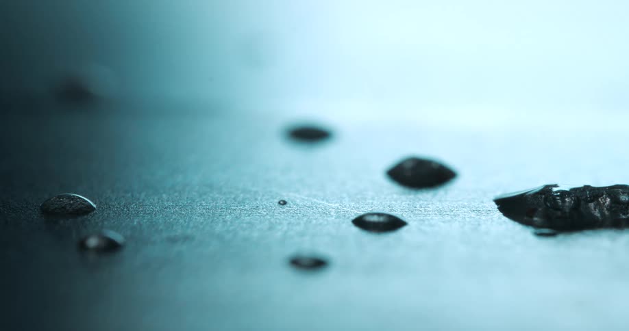 Additional small water droplets fall on a wet surface