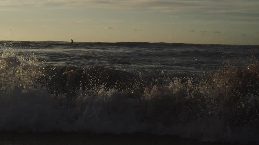 A person is on their surfboard in the ocean