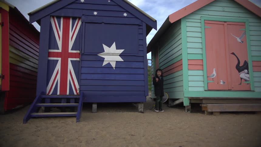 Child stands between colorful buildings