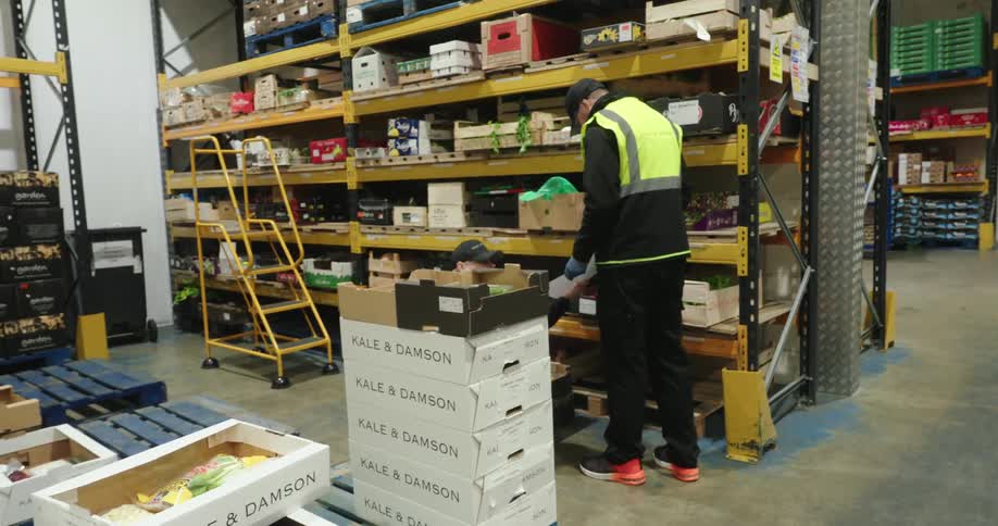Employees are lifting boxes and working in the warehouse