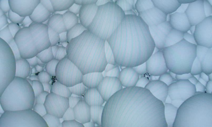 A camera moves through white circular objects