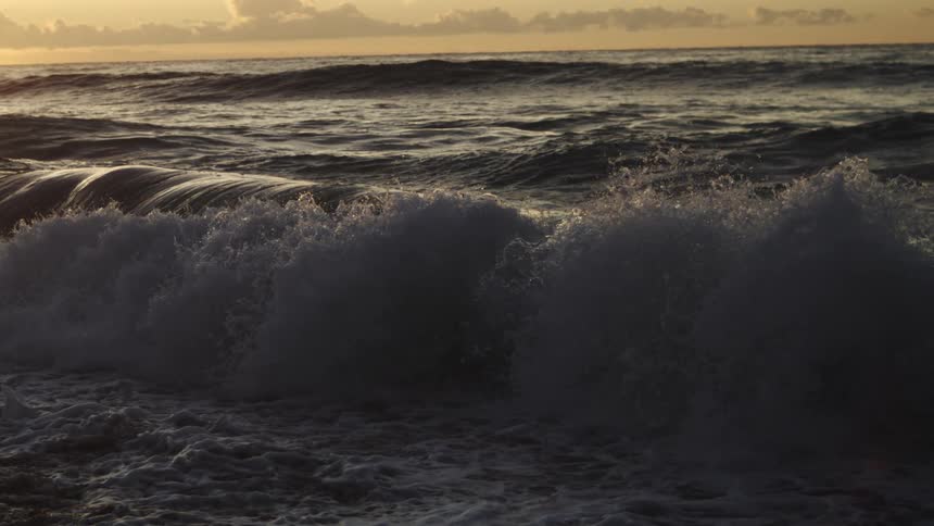 The beach water is rough with many waves