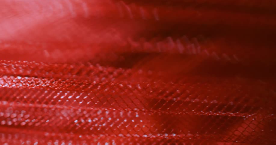 Red texture with interlaced pattern is seen in closeup with reflected shine
