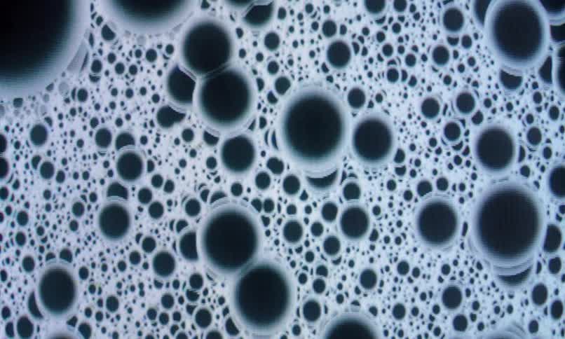 Dark blue bubbles with grey edges are constantly falling in a chaotic manner