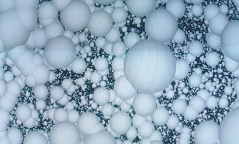 Clusters of digitally animated white balls float around against a black background